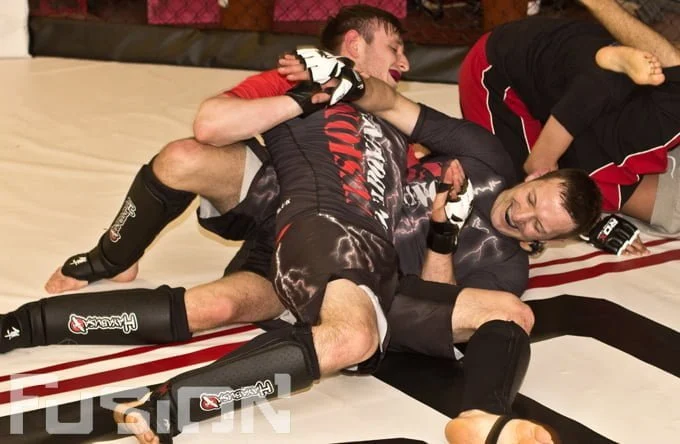 Mixed martial arts grappling in cage